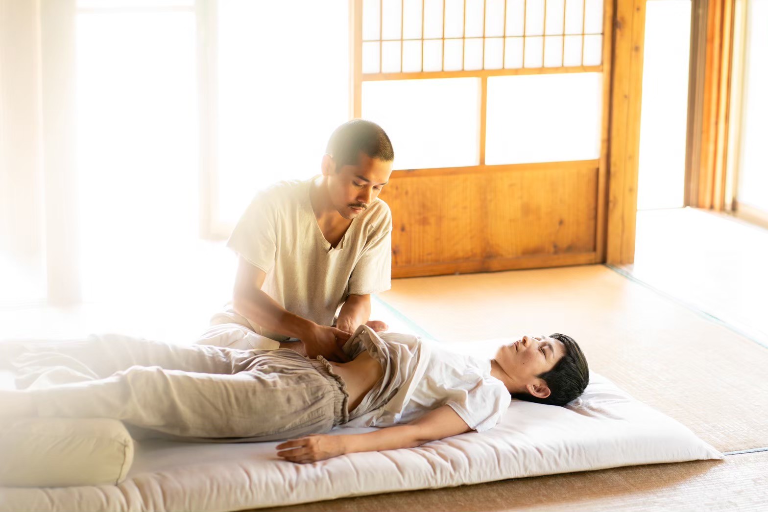 ドライリンパドレナージュ・腸もみ・睡眠マッサージを受ける様子。ゆったりとした空間でお腹に優しく触れている場面