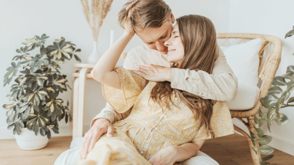 甘えられない女性が旦那さんに身を委ねて可愛く甘えられるようになる過程を象徴する、優しく抱きしめ合う夫婦の写真