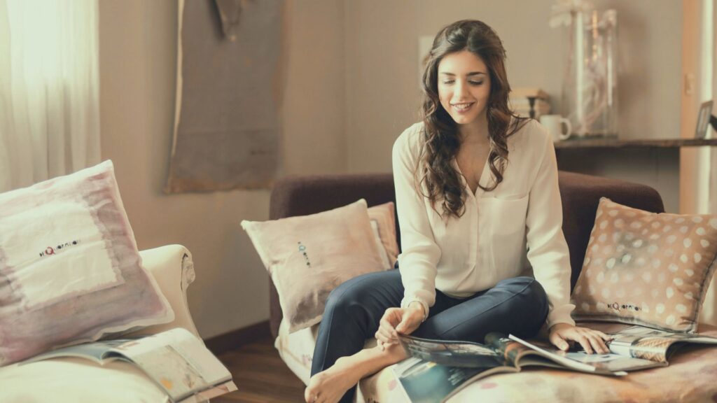 リラックスした表情で雑誌を読む女性｜女性性を高める暮らし方と特徴を表す自然体の時間