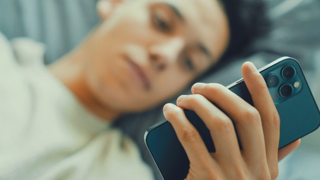 スマートフォンを見る女性｜情報過多・SNS・スマホ依存が睡眠不足や自律神経の乱れにつながるイメージ