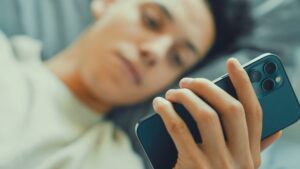 スマートフォンを見る女性｜情報過多・SNS・スマホ依存が睡眠不足や自律神経の乱れにつながるイメージ